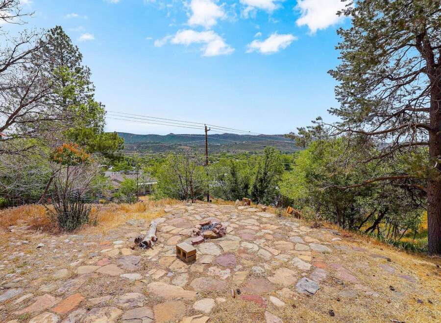 Enjoy breathtaking panoramic views from this stunning property, featuring a natural stone patio and a cozy fire pit perfect for evening gatherings.