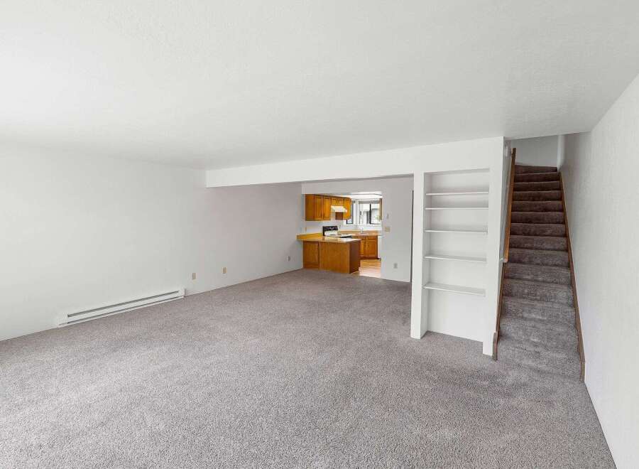 Step into this spacious living area featuring plush carpeting and a convenient heating unit.
