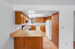 This kitchen features warm wood cabinetry and a spacious countertop, perfect for meal preparation.