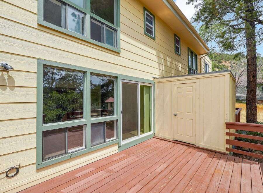 Enjoy the outdoors from this charming home featuring a spacious wooden deck perfect for entertaining.