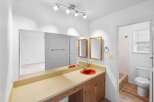 This bathroom features a spacious vanity with a bright orange sink and a large mirror, perfect for getting ready.