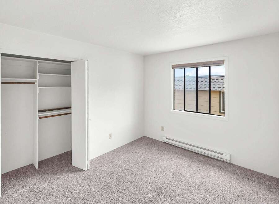 This spacious bedroom features a large closet with ample shelving and a hanging rod, perfect for organizing your belongings.