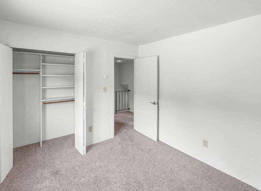 Discover ample storage in this spacious bedroom featuring a large closet with built-in shelving.