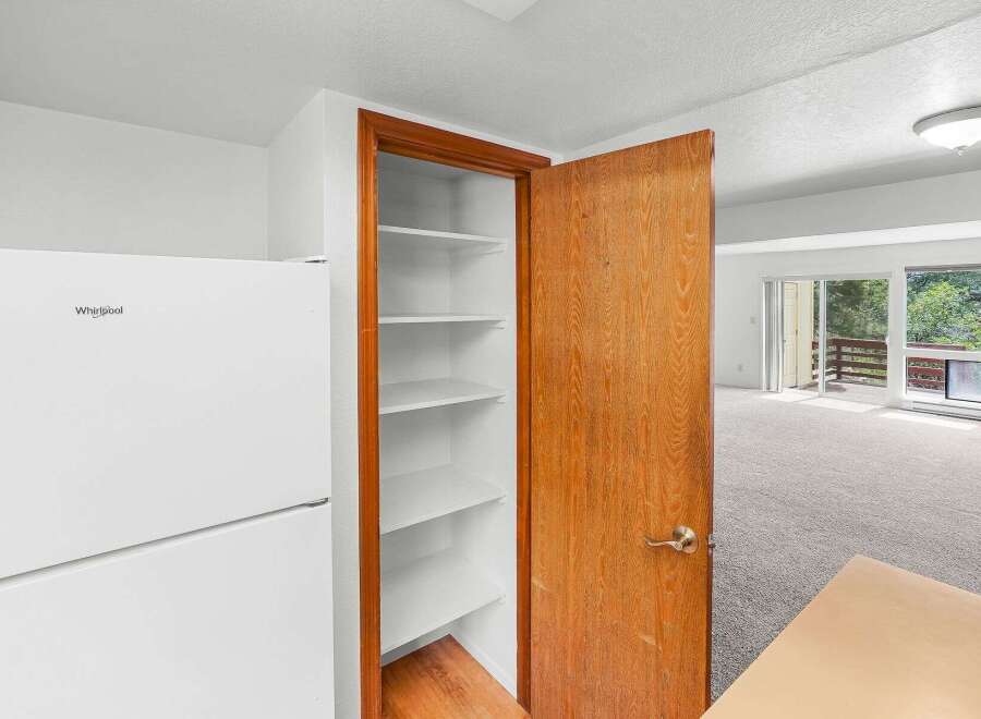 Discover ample storage in this home with a spacious pantry featuring multiple shelves, perfect for organizing your kitchen essentials.