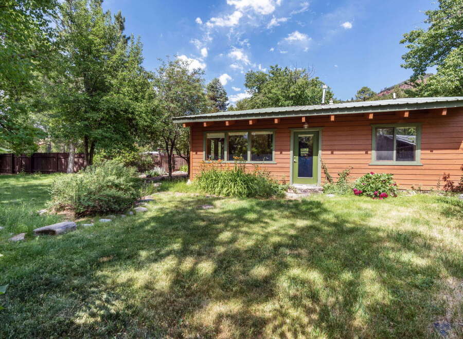 Charming wooden cabin nestled amongst mature trees, offering a serene retreat.