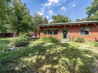 Charming wooden cabin nestled amongst mature trees, offering a serene retreat.