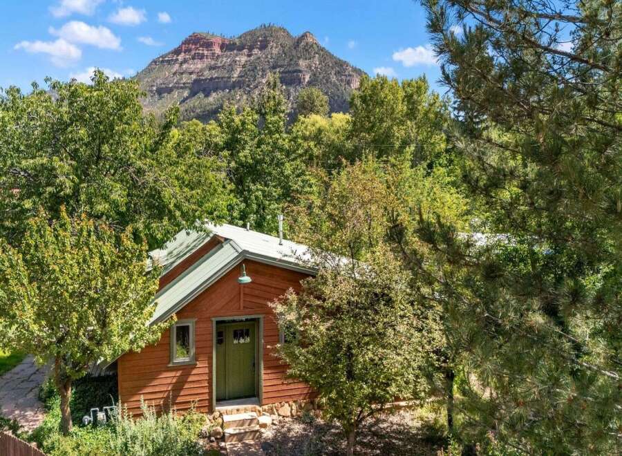 Nestled amidst lush greenery, this charming cabin offers a serene retreat with a picturesque mountain backdrop.