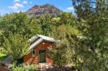 Nestled amidst lush greenery, this charming cabin offers a serene retreat with a picturesque mountain backdrop.
