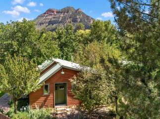 Nestled amidst lush greenery, this charming cabin offers a serene retreat with a picturesque mountain backdrop.