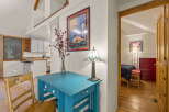 Discover this charming property featuring a bright turquoise desk and a vintage wooden chair, perfect for a cozy workspace.