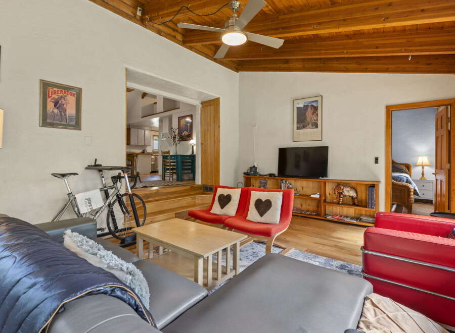 Experience comfortable living in this inviting space, featuring a spacious living area with a mounted TV and a cozy seating arrangement.
