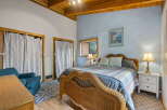 Experience coastal charm in this inviting bedroom featuring a cozy wicker bed and a serene blue accent wall.