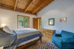 This charming bedroom features a cozy bed with a colorful striped blanket, perfect for relaxation.