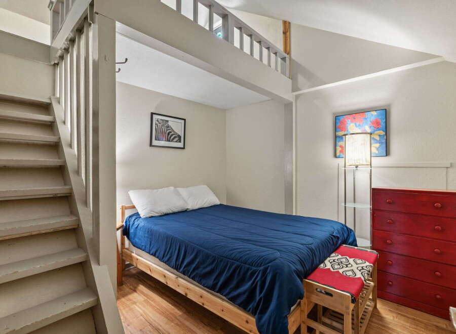 Discover this charming bedroom featuring a cozy loft space accessible by stairs, perfect for maximizing living area.