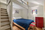 Discover this charming bedroom featuring a cozy loft space accessible by stairs, perfect for maximizing living area.