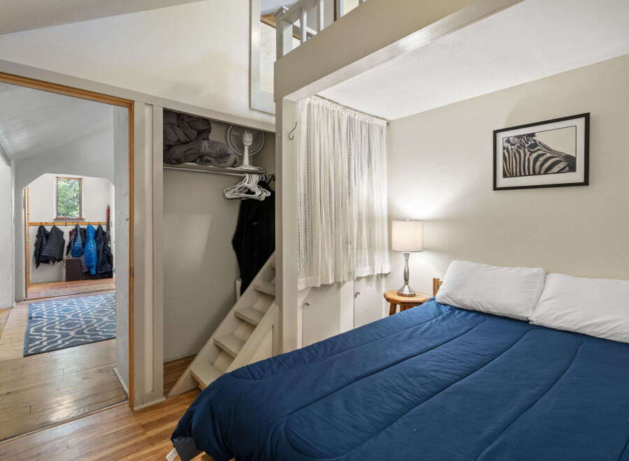 Discover this cozy bedroom featuring a comfortable queen-sized bed with crisp white pillows and a deep blue comforter.