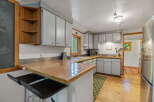 Discover this charming kitchen featuring a unique tiled countertop and a built-in wooden shelf unit, perfect for storage and display.