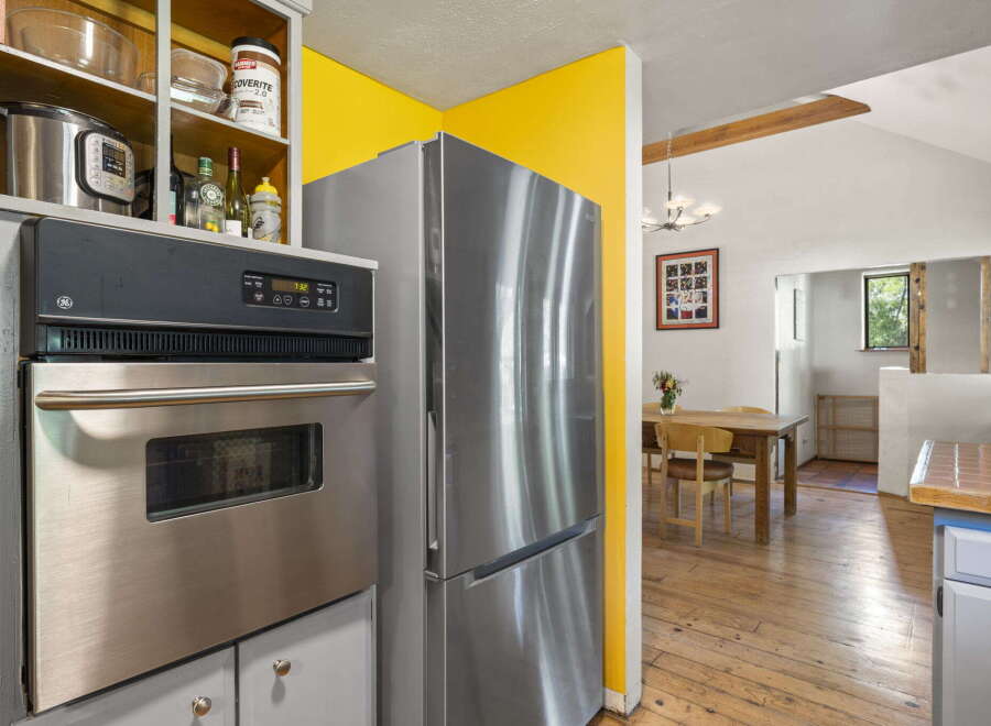 Discover a charming kitchen featuring a sleek stainless steel refrigerator and a built-in oven, perfect for culinary adventures.