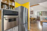 Discover a charming kitchen featuring a sleek stainless steel refrigerator and a built-in oven, perfect for culinary adventures.