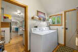 This charming laundry room features a white top-loading washer and dryer set, perfect for handling household chores.