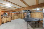 This rustic basement features a custom-built wooden bar area, perfect for entertaining guests.