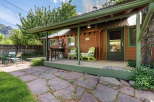 Enjoy outdoor living with a covered porch featuring two charming green chairs, perfect for relaxing.