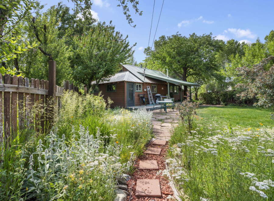 Discover this charming property featuring a cozy cabin nestled amidst lush greenery and vibrant gardens.