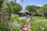 Discover this charming property featuring a cozy cabin nestled amidst lush greenery and vibrant gardens.