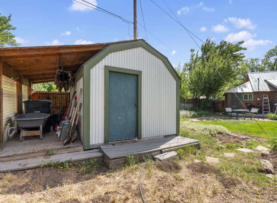 Discover a charming backyard with a versatile shed, perfect for storage or a workshop.