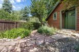 Discover a charming backyard oasis featuring a rustic wooden cabin with a vibrant green door and window trim.
