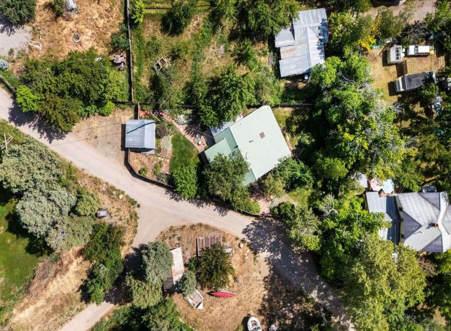 Discover this expansive property featuring multiple structures nestled amongst mature trees.