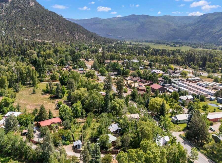 Nestled amidst lush greenery and rolling hills, this property offers a serene escape with its charming homes and abundant trees.