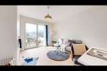 Experience modern living in this bright and airy apartment, featuring a spacious living area with large windows offering stunning mountain views.