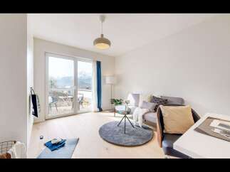 Experience modern living in this bright and airy apartment, featuring a spacious living area with large windows offering stunning mountain views.