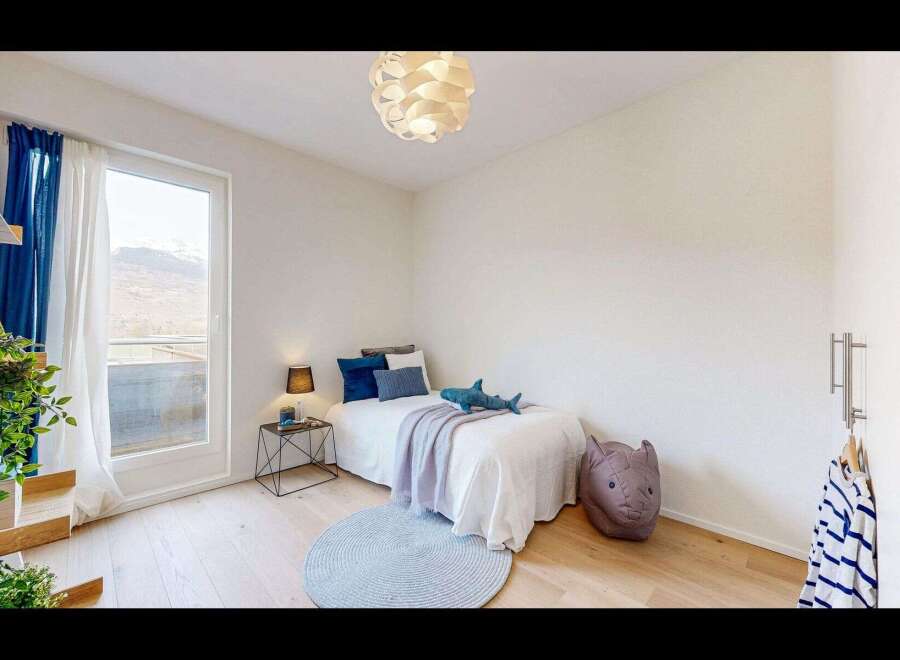 Discover this charming bedroom, perfect for a child or guest room, featuring a cozy single bed adorned with playful shark and rhino plush toys.