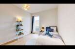Discover this charming bedroom featuring a cozy single bed adorned with plush pillows and a playful shark plushie.