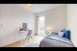 Discover this charming bedroom featuring a cozy bed with plush blue and grey bedding, perfect for relaxation.