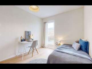 Discover this charming bedroom featuring a cozy bed with plush blue and grey bedding, perfect for relaxation.