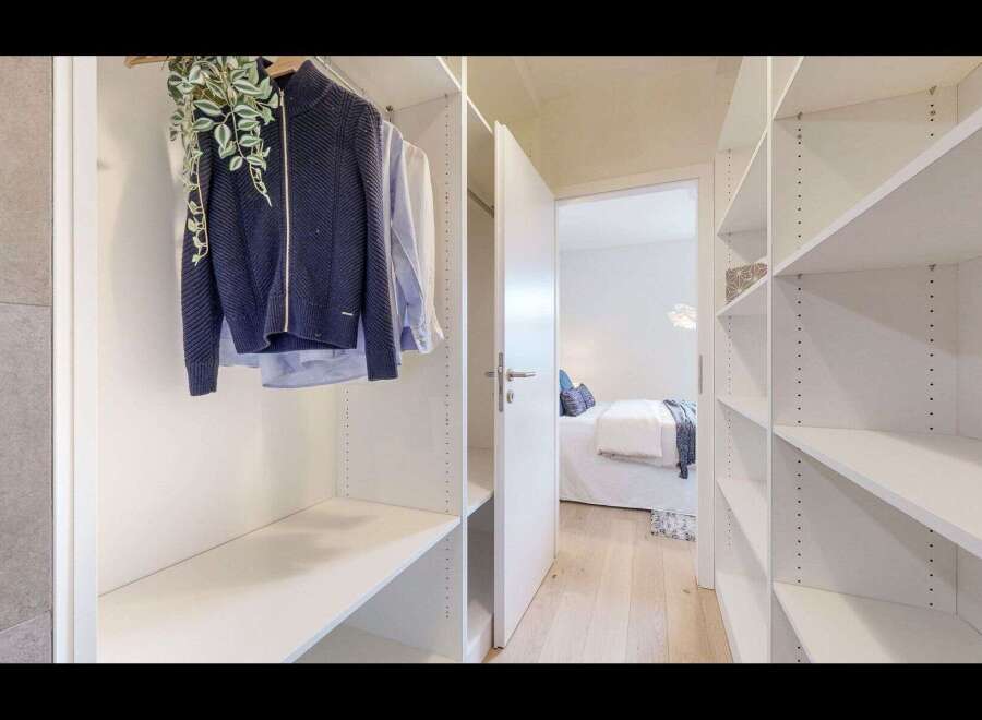 Step into a spacious walk-in closet featuring ample shelving and hanging space, perfect for organizing your wardrobe.
