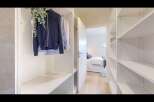 Step into a spacious walk-in closet featuring ample shelving and hanging space, perfect for organizing your wardrobe.