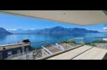 Experience breathtaking panoramic views of a serene lake and majestic mountains from this stunning balcony.