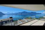 Experience breathtaking panoramic views of a serene lake and majestic mountains from this stunning balcony.