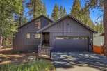 Nestled among tall pine trees, this modern dark gray home offers a serene mountain retreat.