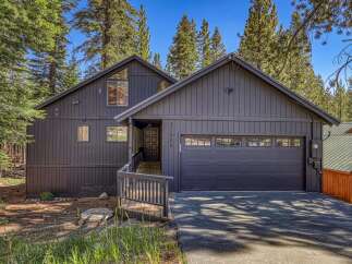 Nestled among tall pine trees, this modern dark gray home offers a serene mountain retreat.