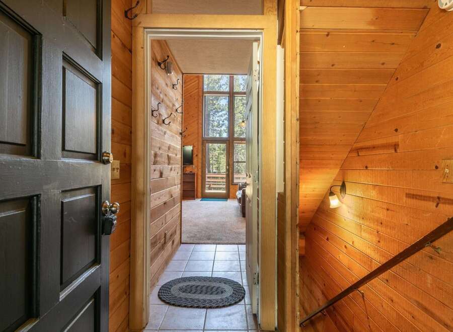 Step into a warm and inviting entryway featuring rustic wood paneling and a tiled floor.