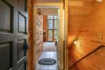 Step into a warm and inviting entryway featuring rustic wood paneling and a tiled floor.