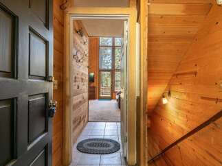 Step into a warm and inviting entryway featuring rustic wood paneling and a tiled floor.