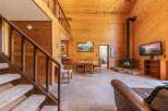 Experience rustic charm in this cozy cabin featuring a soaring wood-paneled ceiling and a warm, inviting fireplace.