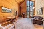 Experience cozy living in this charming cabin featuring a vaulted wood-paneled ceiling and a stunning floor-to-ceiling window that floods the space with natural light.