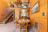 Experience cozy living in this charming cabin-style home featuring a warm, wood-paneled interior and a lofted bedroom area.